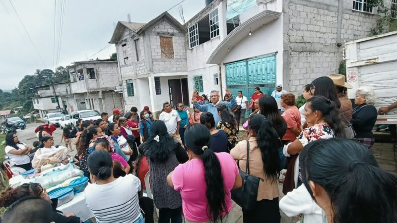 Un hombre habla con vecinas y vecinos reunidos en una colonia de Huauchinango.